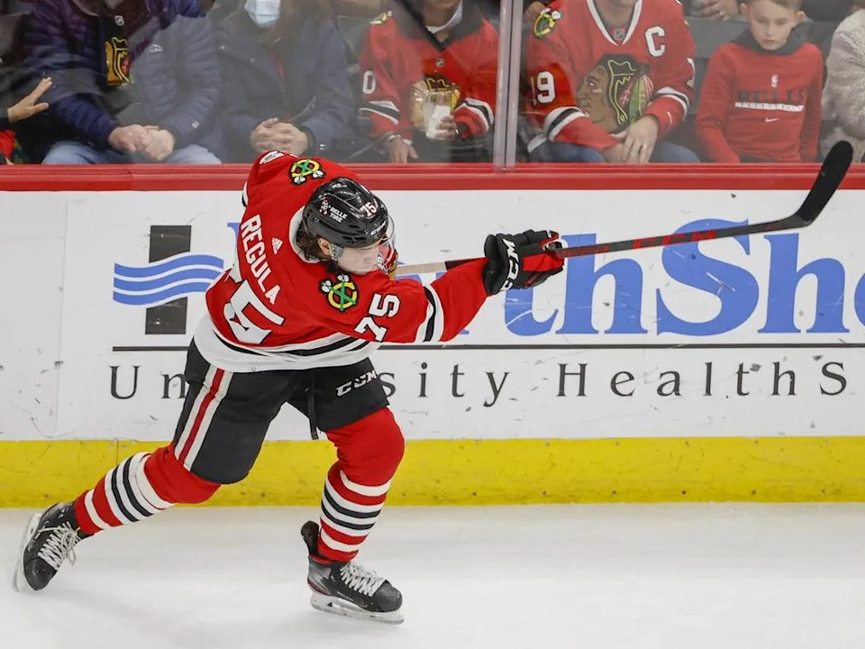 Chicago Blackhawks defenseman Alec Regula (75) shoots and scores against the Calgary Flames during the second period of an NHL hockey game, Monday, April 18, 2022, in Chicago.