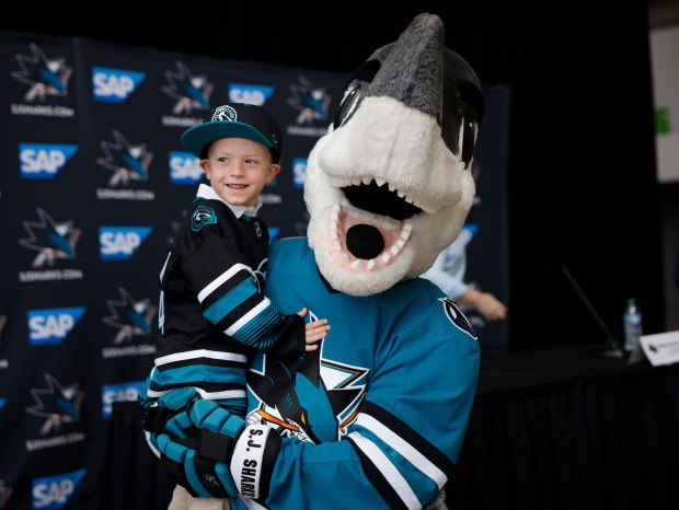 San Jose Sharks mascot SJ Sharkie holds Cal Warsofsky, 4, the son of Ryan Warsofsky who was announced as the new head coach of the San Jose Sharks, at the SAP Center in San Jose, Calif., on Monday, June 17, 2024. (Nhat V. Meyer/Bay Area News Group)