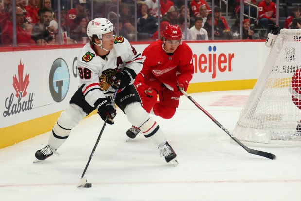 Blackhawks center Connor Bedard looks to make a play in front of the Red Wings' Axel Sandin-Pellikka during the second period of a preseason game Tuesday, Sept. 23, 2025, in Detroit. (Gregory Shamus/Getty Images)