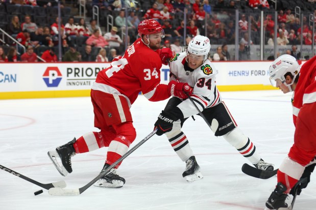 Colton Dach of the Blackhawks tries to get around the stick of the Red Wings' Carter Mazur during a preseason game Tuesday, Sept. 23, 2025, in Detroit. (Gregory Shamus/Getty Images)