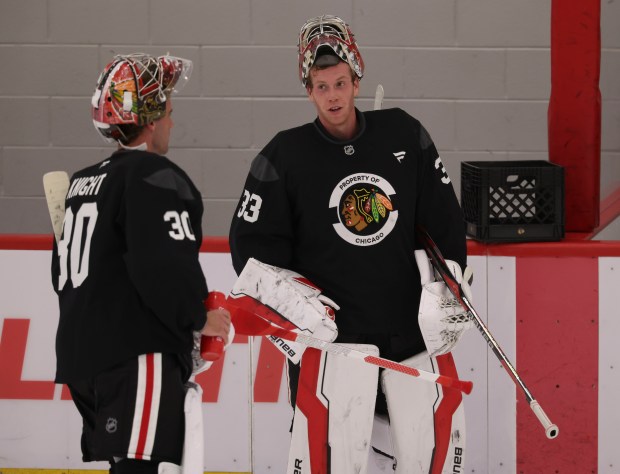 Goaltenders Spencer Knight (30) and Drew Commesso (33) talk during practice Thursday, Sept. 18, 2025, as the Chicago Blackhawks begin training camp at Fifth Third Arena. (Brian Cassella/Chicago Tribune)