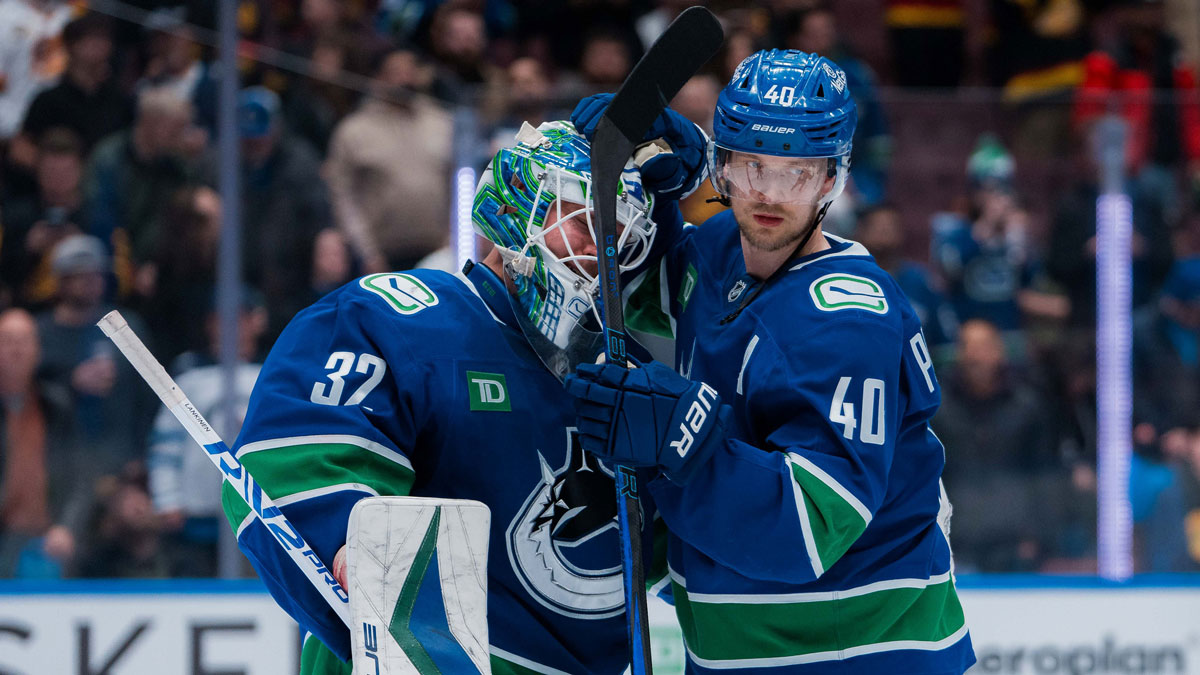 Vancouver Canucks goalie Kevin Lankinen (32) and forward Elias Pettersson (40) celebrate their victory against the Winnipeg Jets at Rogers Arena