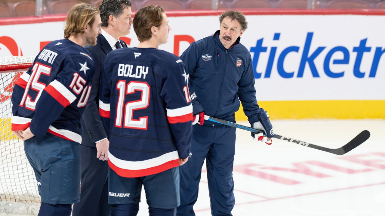 Guy Gaudreau, right, the father of the late Johnny and Matthew Gaudreau joins U.S.A. team players Noah Hanifin (15) and Matt Boldy (12) on the ice during 4 Nations Face-Off hockey practice in Montreal, Tuesday, Feb. 11, 2025.