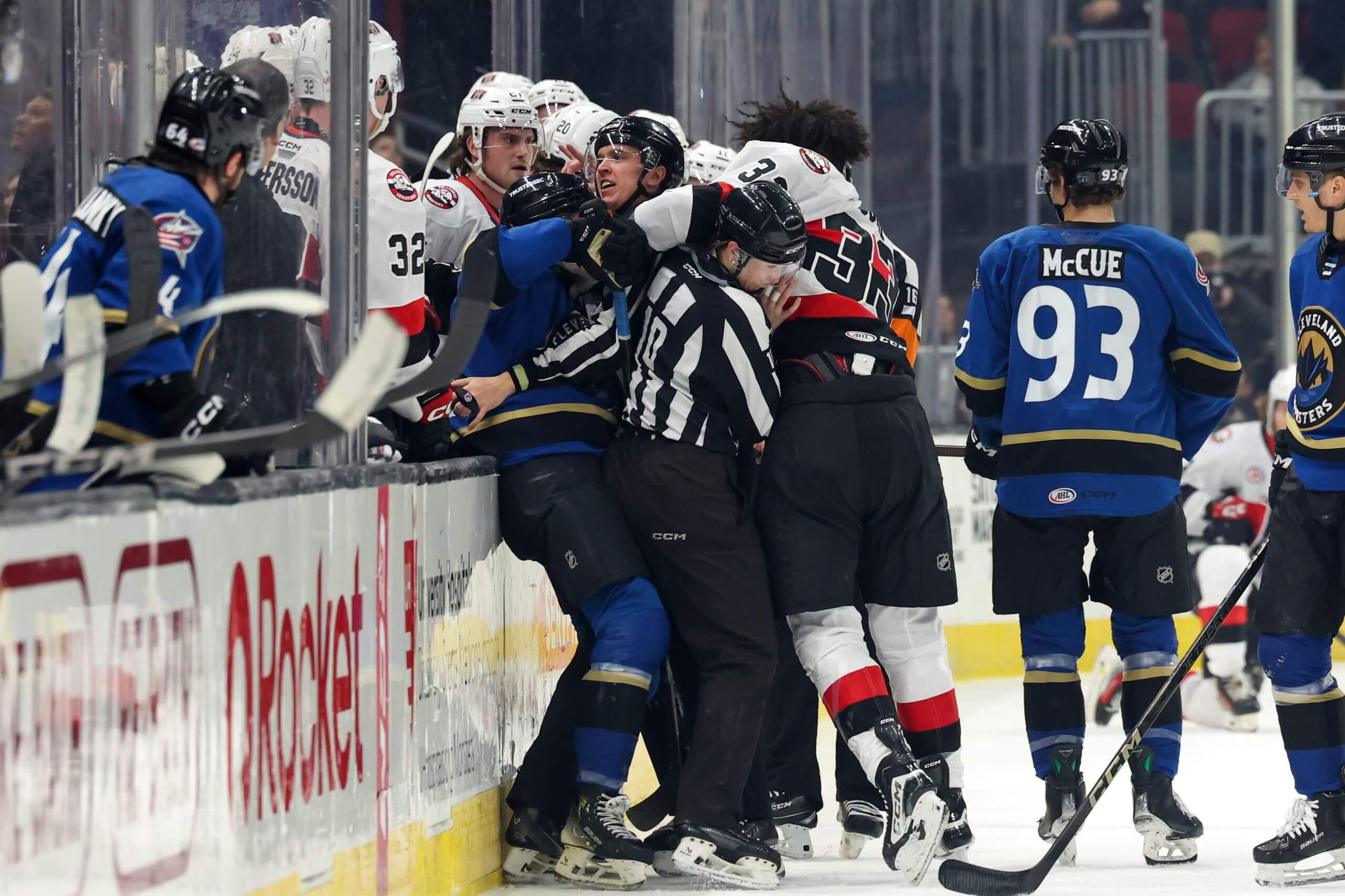 Linesperson Kirsten Welsh, center, breaks up a scrum along the benches during an AHL game last season.