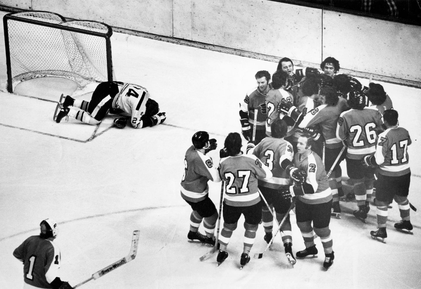 Boston Bruins player Terry O'Reilly, top left, dropped to the ice in disbelief, as the Bruins were defeated 1-0 by the Philadelphia Flyers, in overtime in the Stanley Cup playoffs in Philadelphia, on May 19, 1974. Flyers goalie Bernie Parent, bottom left, moved in to join teammates congratulating Clark on his goal.