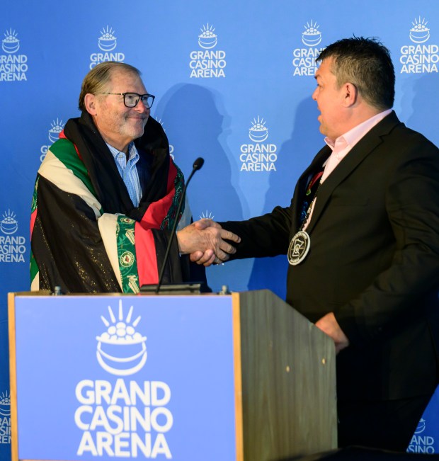 Minnesota Wild owner Craig Leipold, left, shakes hands with Virgil...