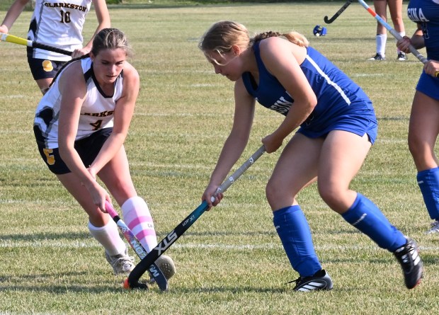 Clarkston's Anna Duggan (No. 4 on left) tries to swipe the ball away from Warren Regina's Izzy Jones (No. 24) during Monday's non-league game on Sept. 8, 2025. (DAN STICKRADT -- MediaNews Group)