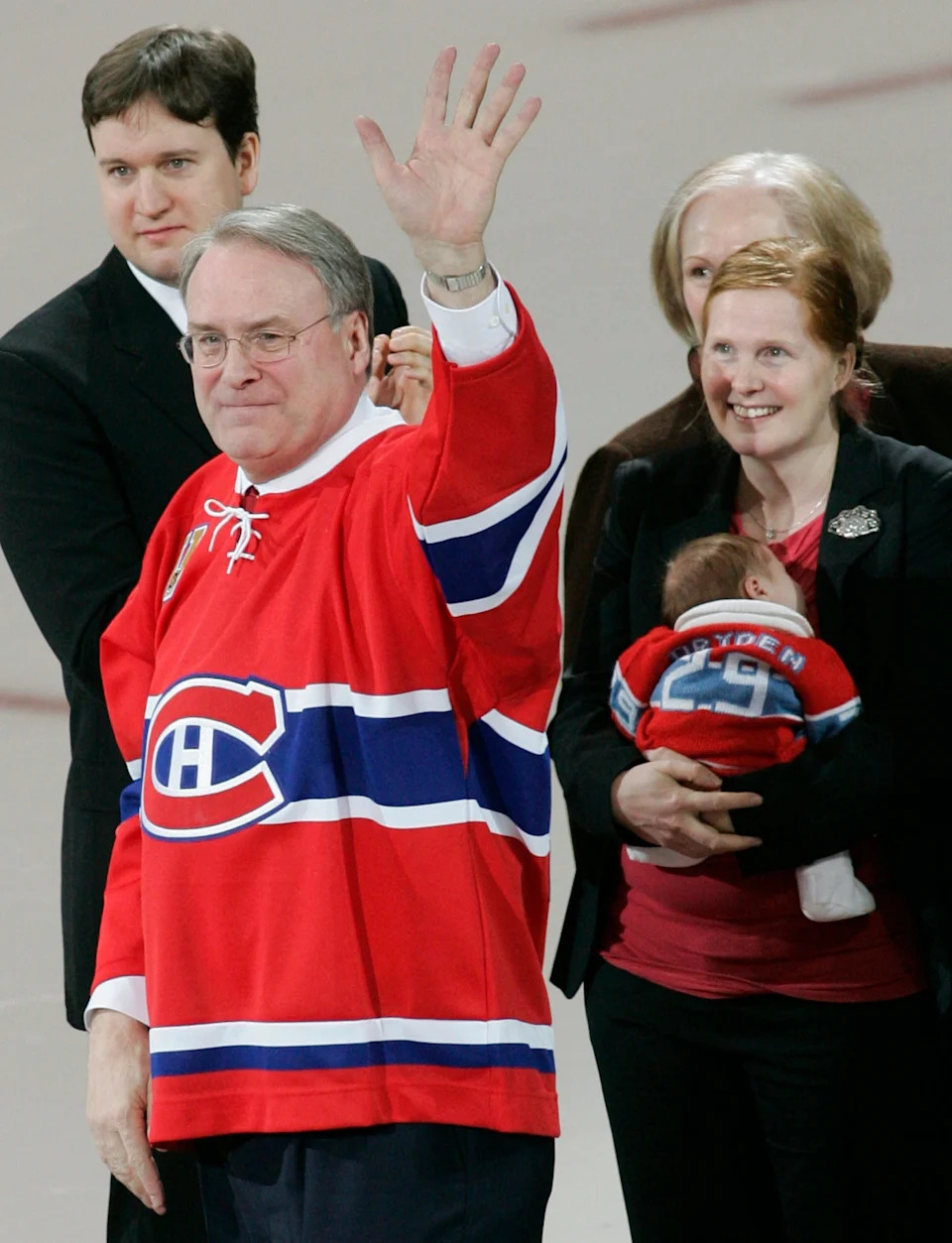 Former Montreal Canadiens goaltender Ken Dryden (2nd L) waves to the crowd as his daughter Sarah and her baby watch during a ceremony to retire his number "29" in Montreal January 29, 2007.