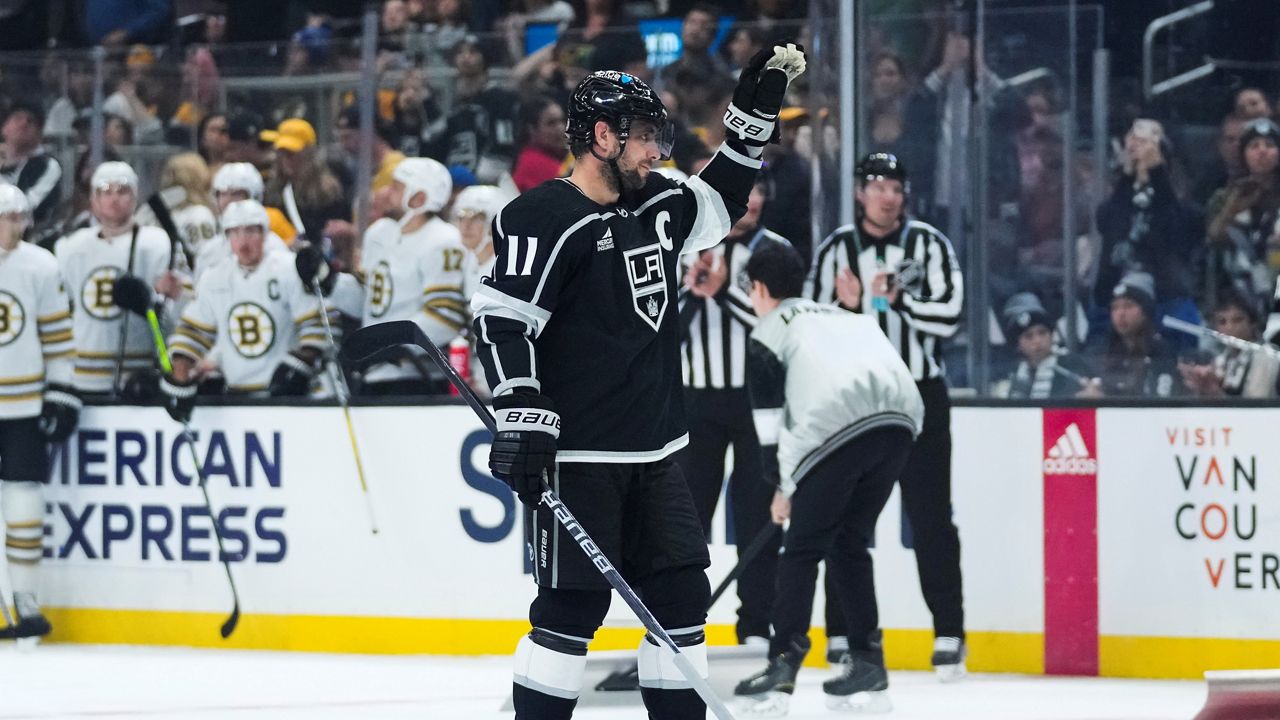 Los Angeles Kings center Anze Kopitar (11) reacts as he is recognized for breaking the team's record for number of games played during the first period of an NHL hockey game against the Boston Bruins Saturday, Oct. 21, 2023, in Los Angeles. (AP Photo/Ashley Landis)