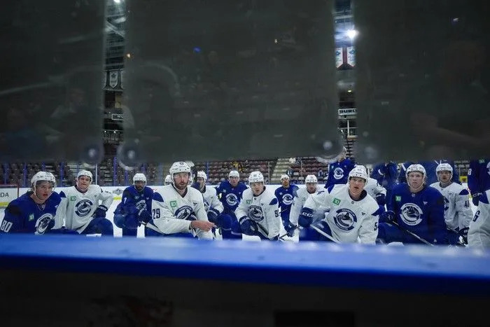 Vancouver Canucks players, including Braeden Cootes (80), Marcus Pettersson (29), Vitali Kravtsov (92), Aatu Raty (54) and Sawyer Mynio (45) listen to instructions for a drill during the opening day of the NHL hockey team’s training camp, in Penticton, B.C., on Thursday, September 18, 2025.