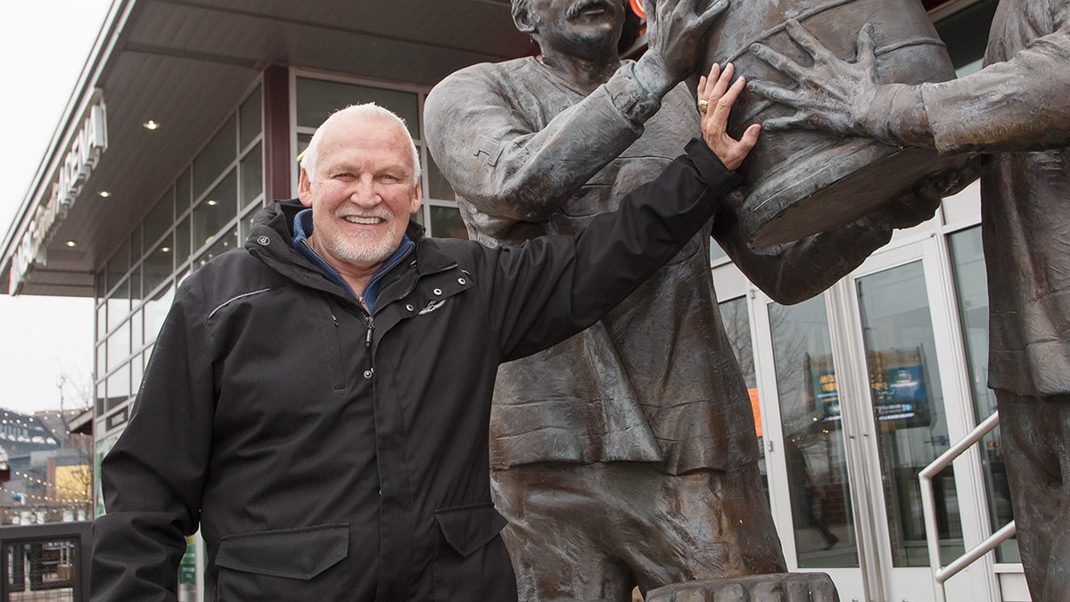 Bernie Parent poses next to statue