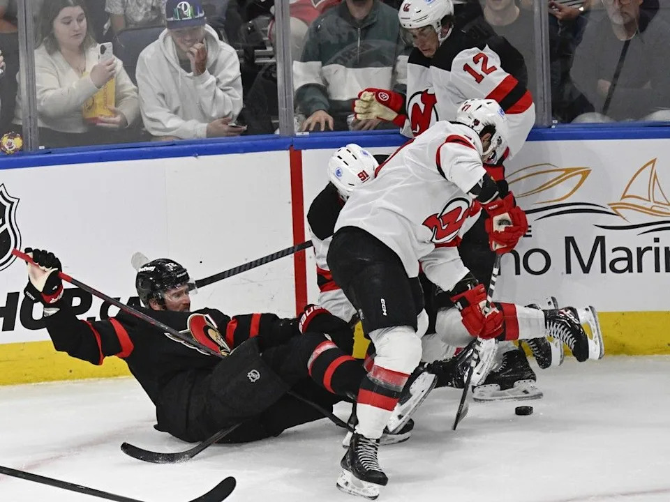 The Ottawa Senators’ Thomas Chabot falls back while fighting for a puck with the New Jersey Devils’ Cody Glass (12), Paul Cotter (47) and Dawson Mercer (91) during the second period.