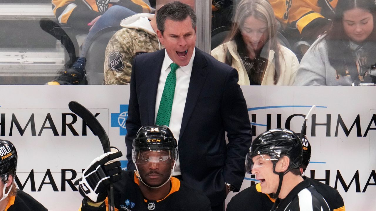 Pittsburgh Penguins head coach Mike Sullivan disagrees with a high sticking call by referee Wes McCauley (4) during the third period of an NHL hockey game against the New Jersey Devils in Pittsburgh, Saturday, March 15, 2025.