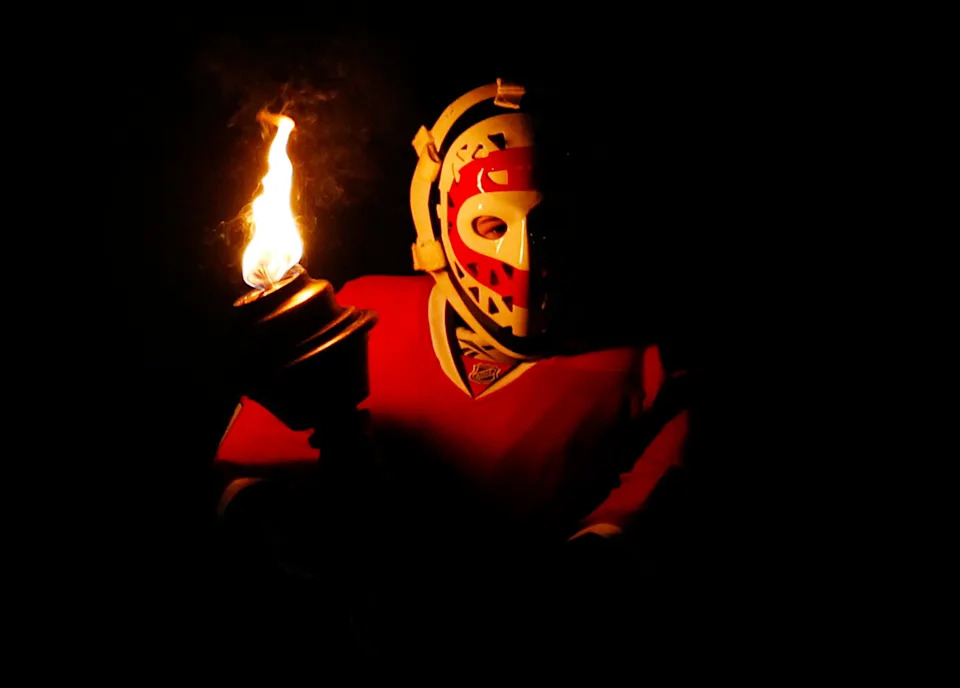 A young hockey player wears the mask of former Montreal Canadiens goalie Ken Dryden.