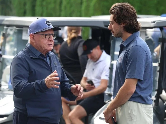  Quinn Hughes speaks with Jim Rutherford at Jake Milford Charity Invitational tournament on Sept. 8.