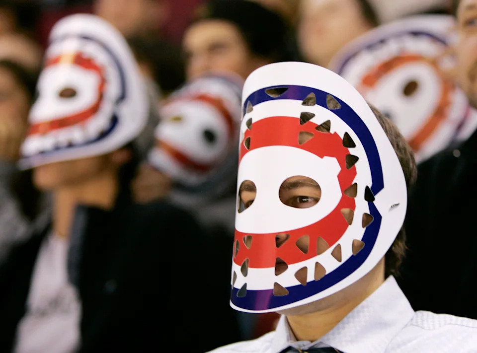 Montreal Canadiens fans wear replica goal masks of former Montreal Canadiens goaltender Ken Dryden as his number "29" is retired.