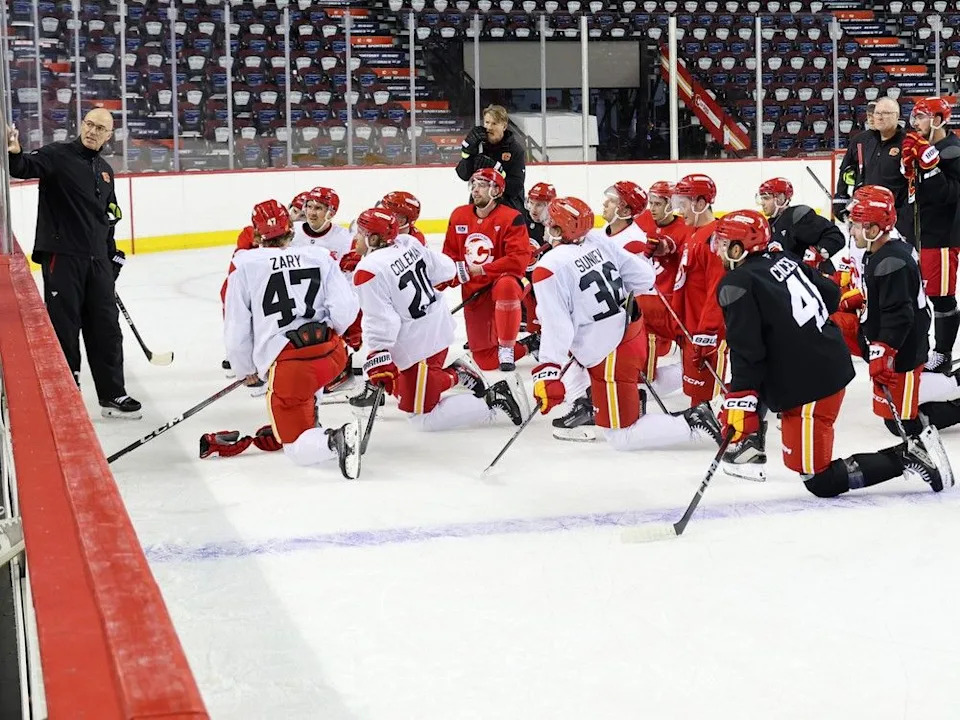  Flames head coach Ryan Huska goes over drills with players during training camp on Thursday.
