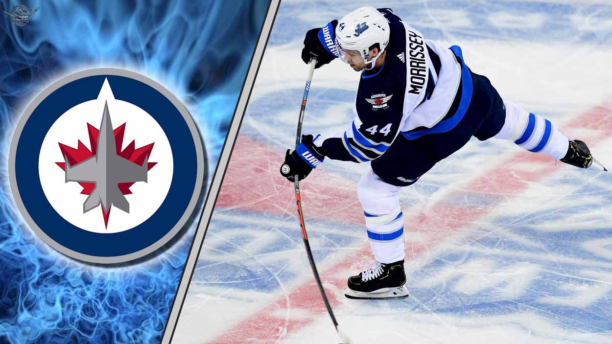 Winnipeg Jets defenseman Josh Morrissey skating with the puck during an NHL game, quarterbacking the power play.