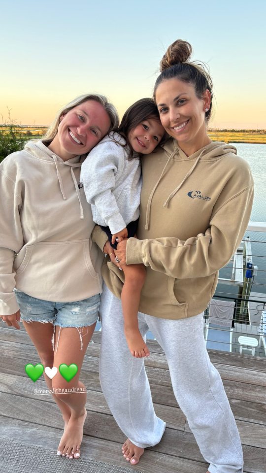 Two women and a child pose for a photo.