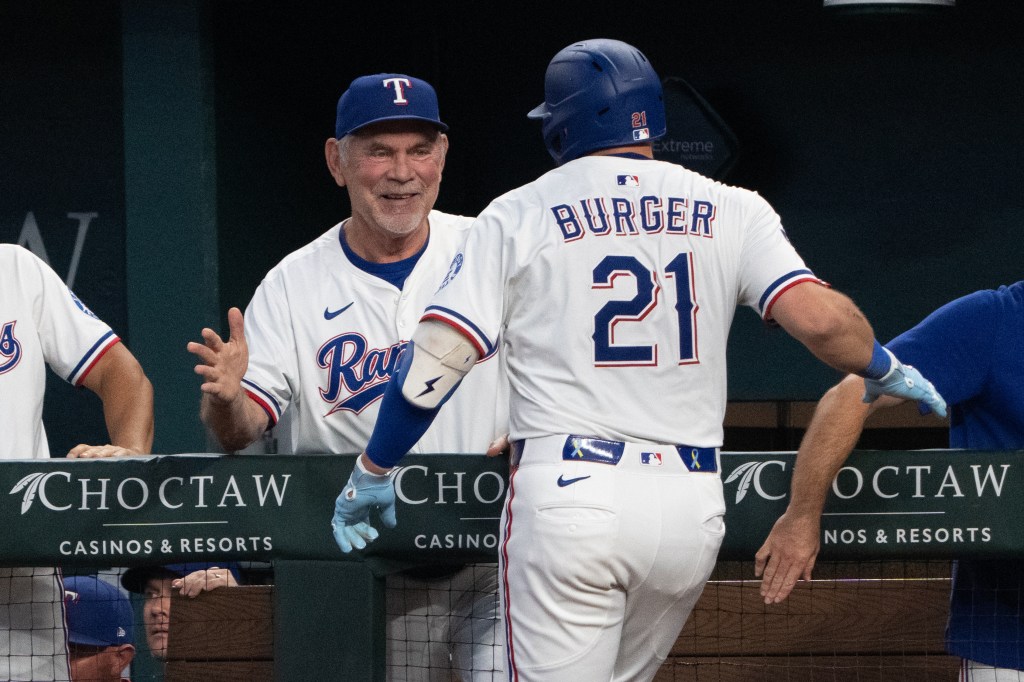 Texas Rangers first baseman Jake Burger celebrating his two-run home run with manager Bruce Bochy.