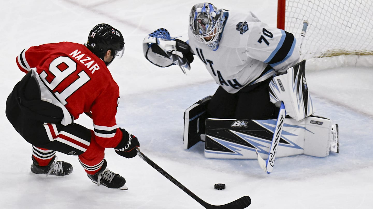 Mar 30, 2025; Chicago, Illinois, USA;  Chicago Blackhawks center Frank Nazar (91) shoots against Utah Hockey Club goaltender Karel Vejmelka (70) during the second period at United Center. Mandatory Credit: Matt Marton-Imagn Images