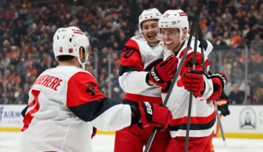Oct 16, 2025; Anaheim, California, USA; Carolina Hurricanes defenseman Alexander Nikishin (21), right, celebrates with teammates after scoring his first NHL goal during the third period against the Anaheim Ducks at Honda Center. Mandatory Credit: William Liang-Imagn Images