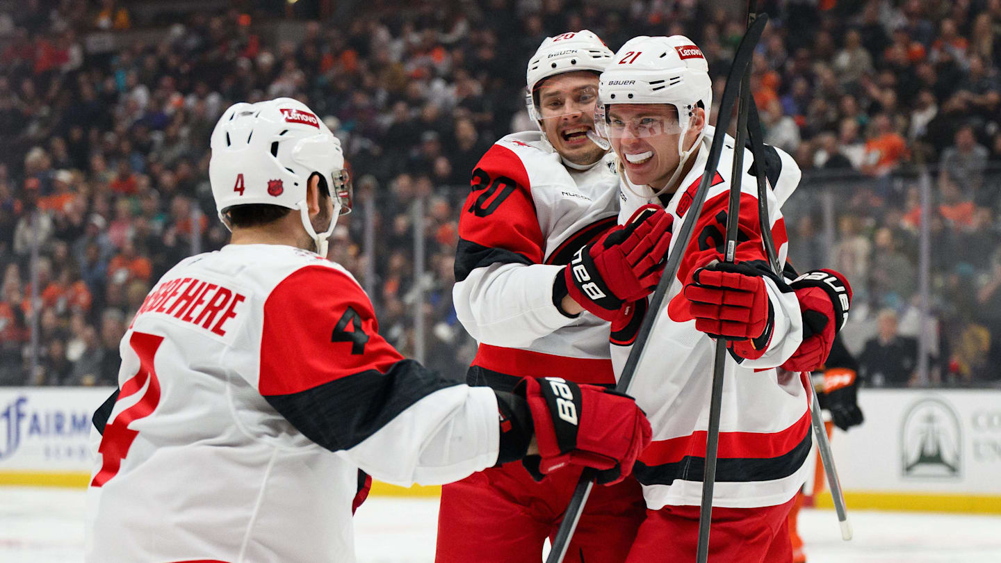 Oct 16, 2025; Anaheim, California, USA; Carolina Hurricanes defenseman Alexander Nikishin (21), right, celebrates with teammates after scoring his first NHL goal during the third period against the Anaheim Ducks at Honda Center. Mandatory Credit: William Liang-Imagn Images