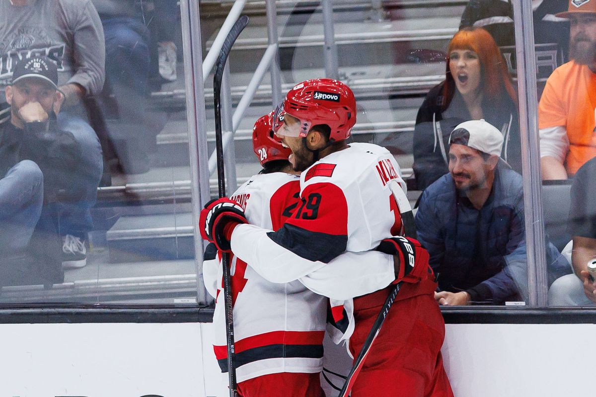 Carolina Hurricanes D K'Andre Miller (19) and C Seth Jarvis (24) celebrate after an overtime win during an NHL game against the Los Angeles Kings at the Crypto.com Arena on October 18, 2025 in Los Angeles, California.