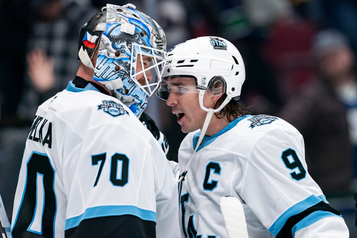FILE - Utah Hockey Club goaltender Karel Vejmelka (70) and Clayton Keller (9) celebrate after defeating the Vancouver Canucks in an NHL hockey game in Vancouver, British Columbia, Sunday, March 16, 2025. (Ethan Cairns/The Canadian Press via AP, File)