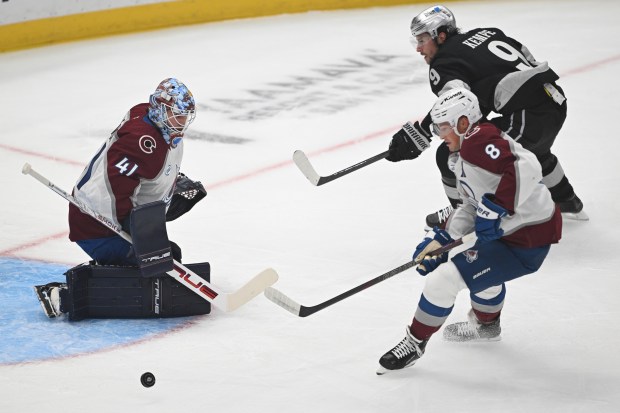 The Kings’ Adrian Kempe (9) gets a shot off as...