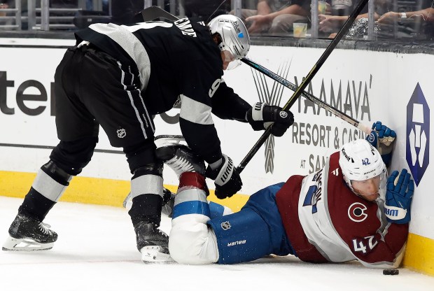 The Kings’ Adrian Kempe, left, checks the Colorado Avalanche’s Josh...