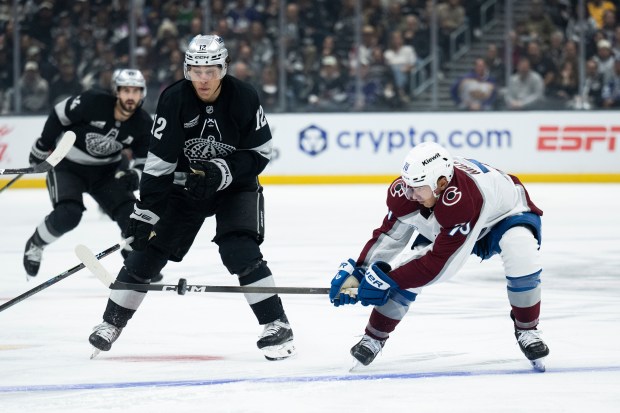 Colorado Avalanche defenseman Sam Malinski, right, stops the puck in...