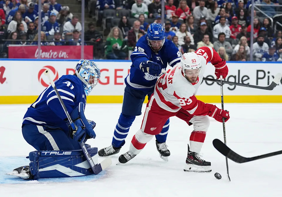 Detroit Red Wings right wing Alex DeBrincat (93) battles for the puck with Toronto Maple Leafs defenseman Oliver Ekman-Larsson (95) in front of goaltender Anthony Stolarz (41) during the second period at Scotiabank Arena in Toronto on Thursday, Oct. 2, 2025.