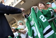 Dallas Stars center Roope Hintz gives autograph to a fan during Victory Green Carpet Walk,...