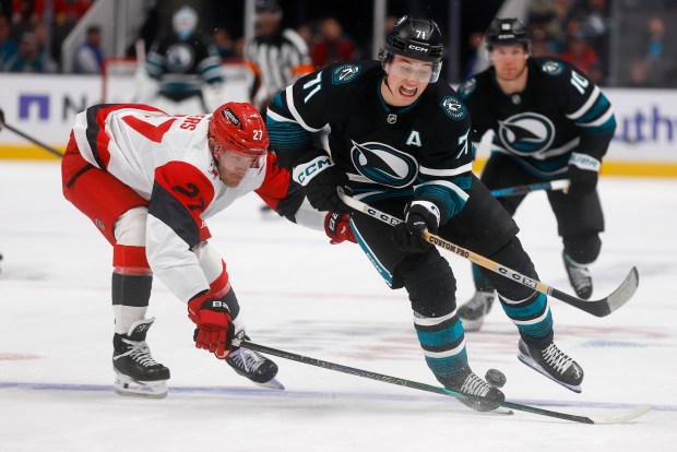 San Jose Sharks' Macklin Celebrini (71) fights for the puck against Carolina Hurricanes' Nikolaj Ehlers (27) in the third period at the SAP Center in San Jose, Calif., on Tuesday, Oct. 14, 2025. (Nhat V. Meyer/Bay Area News Group)
