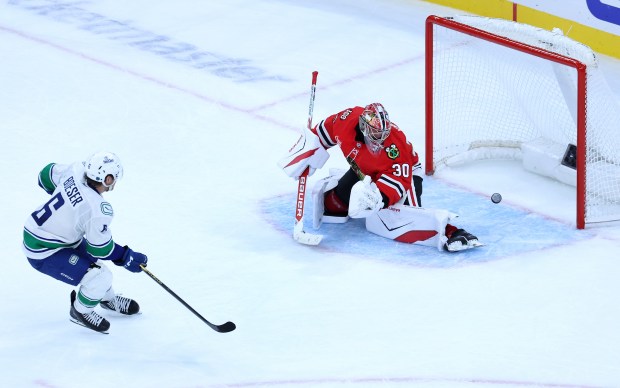 Chicago Blackhawks goaltender Spencer Knight (30) is unable to stop Vancouver Canucks right wing Brock Boeser (6) from scoring the game-winning sudden-death goal in the shootout of a game at the United Center in Chicago on Oct. 17, 2025. (Chris Sweda/Chicago Tribune)