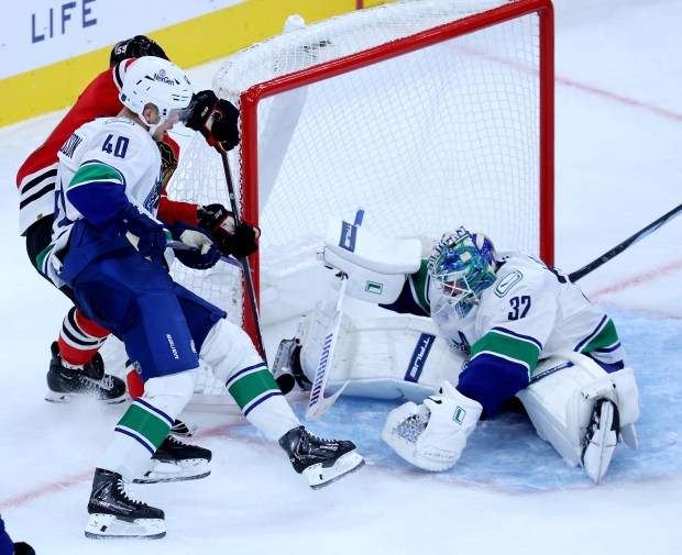 Vancouver Canucks goaltender Kevin Lankinen (32) tries to prevent Chicago Blackhawks left wing Tyler Bertuzzi from scoring a goal in the third period of a game at the United Center in Chicago on Oct. 17, 2025. Initially the referees called it a goal for Bertuzzi, then changed it to goalie interference with the goal for Bertuzzi being taken away. (Chris Sweda/Chicago Tribune)