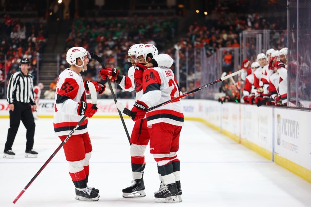Carolina Hurricanes players embrace teammate Seth Jarvis (24) after he...