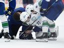 Vancouver Canucks center Filip Chytil is tended to after he was injured during the first period of an NHL hockey game against the Washington Capitals, Sunday, Oct. 19, 2025, in Washington.