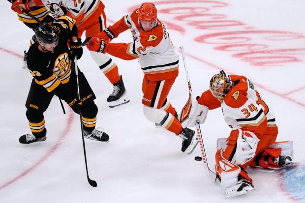 Ducks goaltender Petr Mrazek, right, drops to make a save...