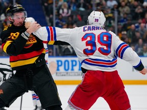 Marcus Pettersson fights Sam Carrick during the first period