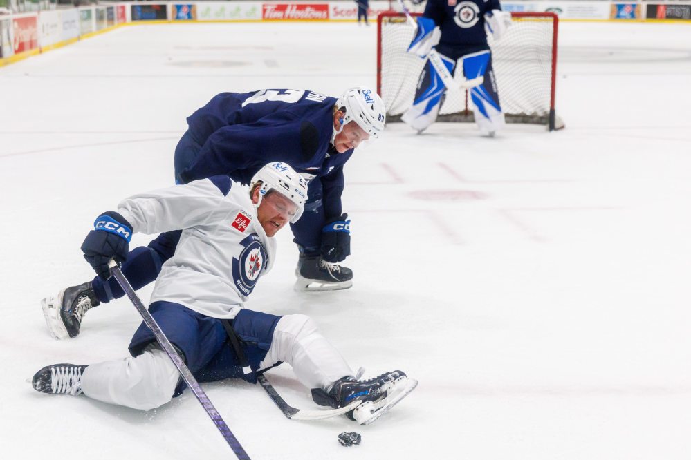 MIKE DEAL / FREE PRESS Winnipeg Jets’ Mason Shaw (23) slips during a battle for the puck with Dylan Anhorn (83) during training camp at Hockey For All Centre this September. Shaw was loaned to the Manitoba Moose for their training camp last week.