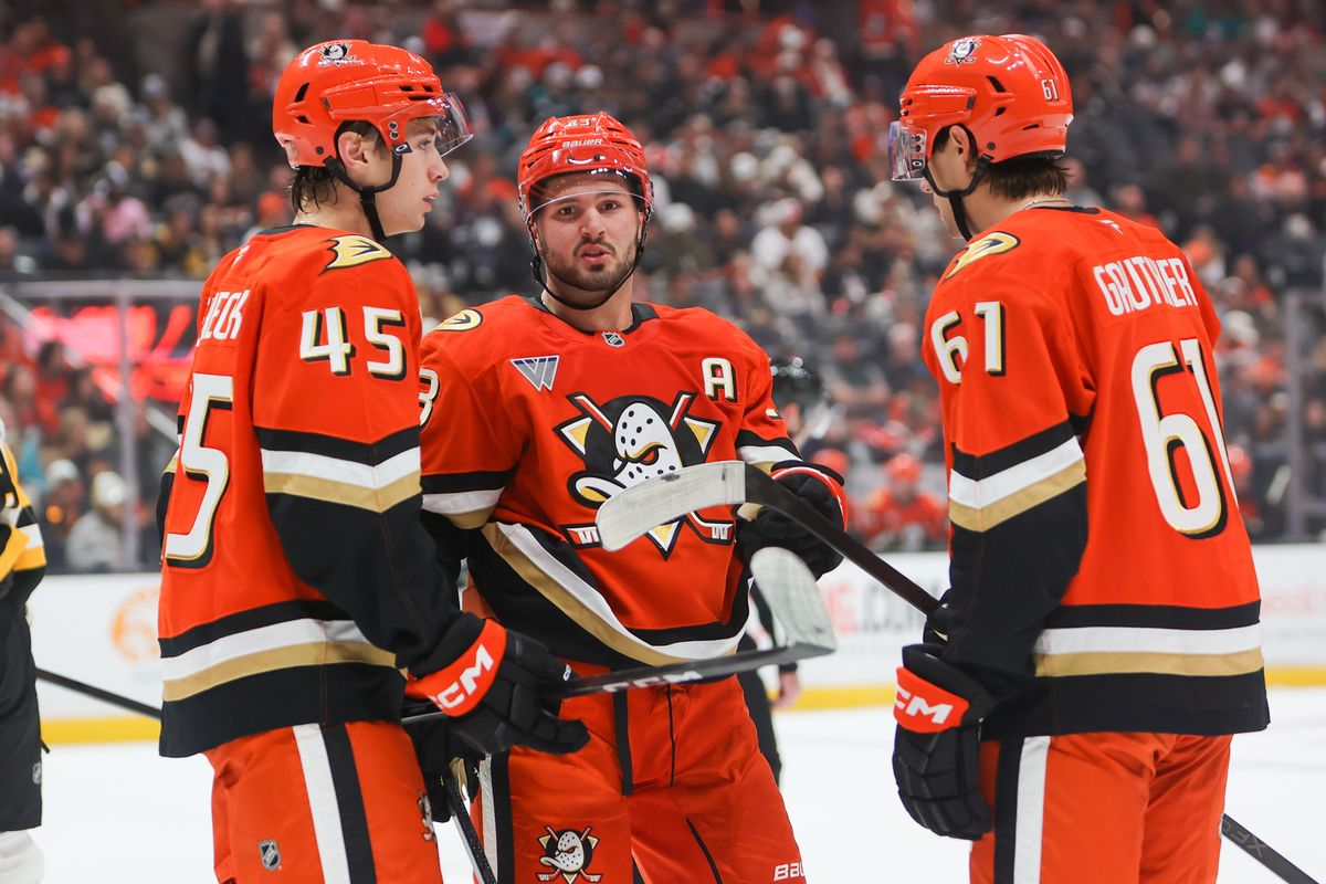#23 Mason McTavish of the Anaheim Ducks discusses strategy with teammates #45 RW Beckett Sennecke and #61 LW Cutter Gauthier during an NHL game against the Pittsburg Penguins on October 14, 2025 in Anaheim, CA.