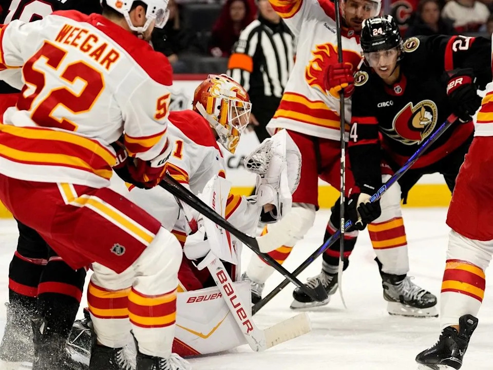  Flames goaltender Devin Cooley makes a save in front of Senators forward Dylan Cozens on Thursday.