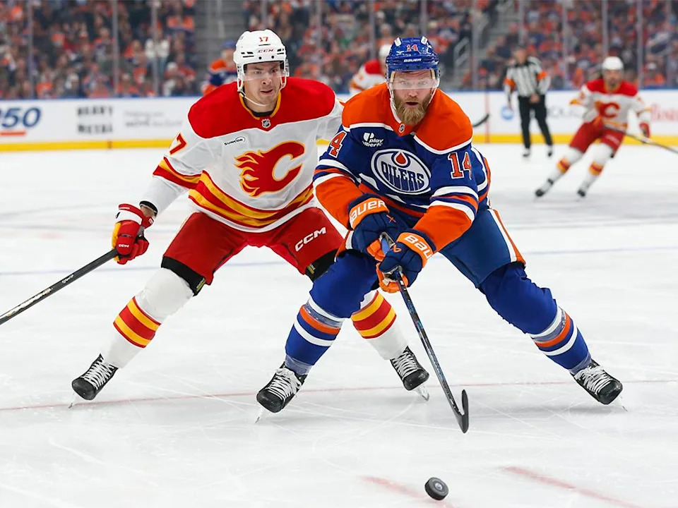  Mattias Ekholm #14 of the Edmonton Oilers defends against Yegor Sharangovich #17 of the Calgary Flames during the first period at Rogers Place on Wednesday, Oct. 8, 2025, in Edmonton, Canada.