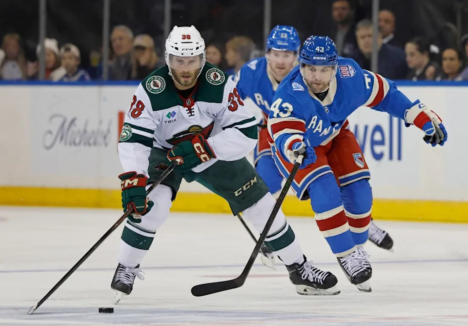 Rangers left wing Conor Sheary tries to steal the puck from Wild right wing Ryan Hartman. JASON SZENES/ NY POST