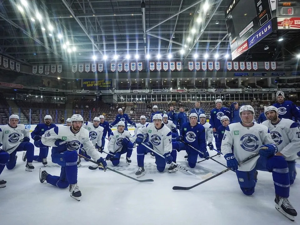 Vancouver Canucks players, including Marcus Pettersson (29), Aatu Raty (54), Brock Boeser (6) and Derek Forbort (27) listen to instructions for a drill during the opening day of the NHL hockey team’s training camp, in Penticton, B.C., on Thursday, September 18, 2025.