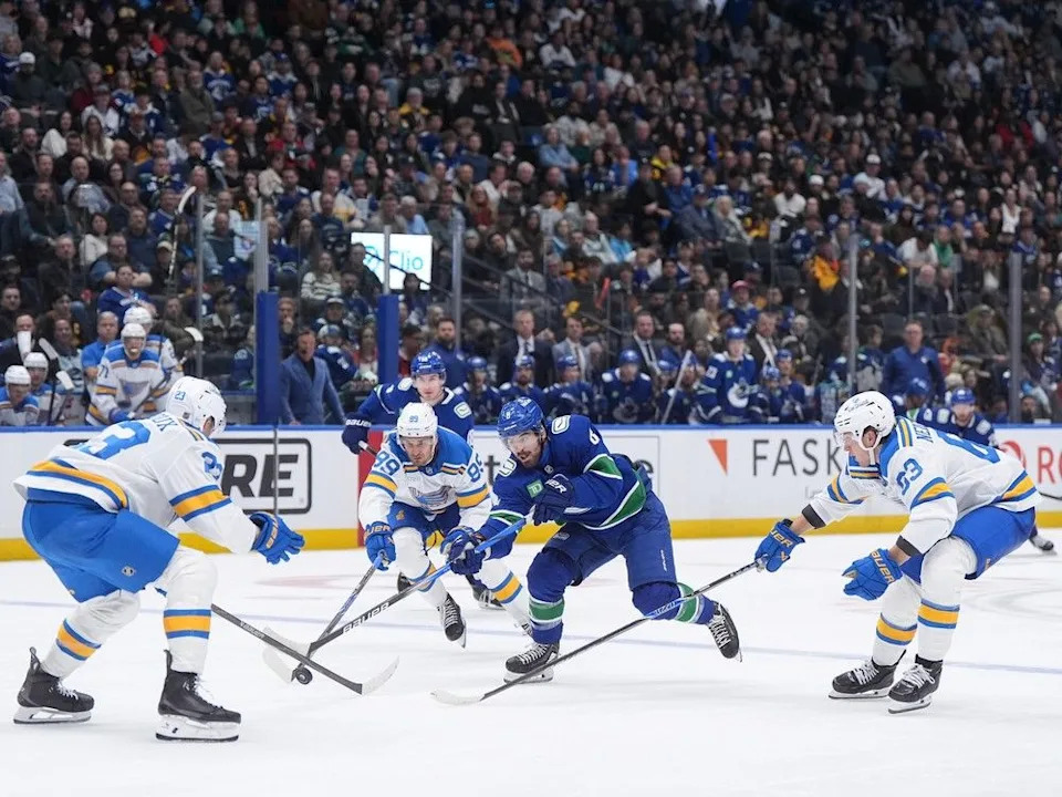  Conor Garland, front centre, tries to skate with the puck past St. Louis Blues’ Logan Mailloux, left, Pavel Buchnevich, back centre, and Jake Neighbours, right, during the third period on Monday, Oct. 13, 2025.