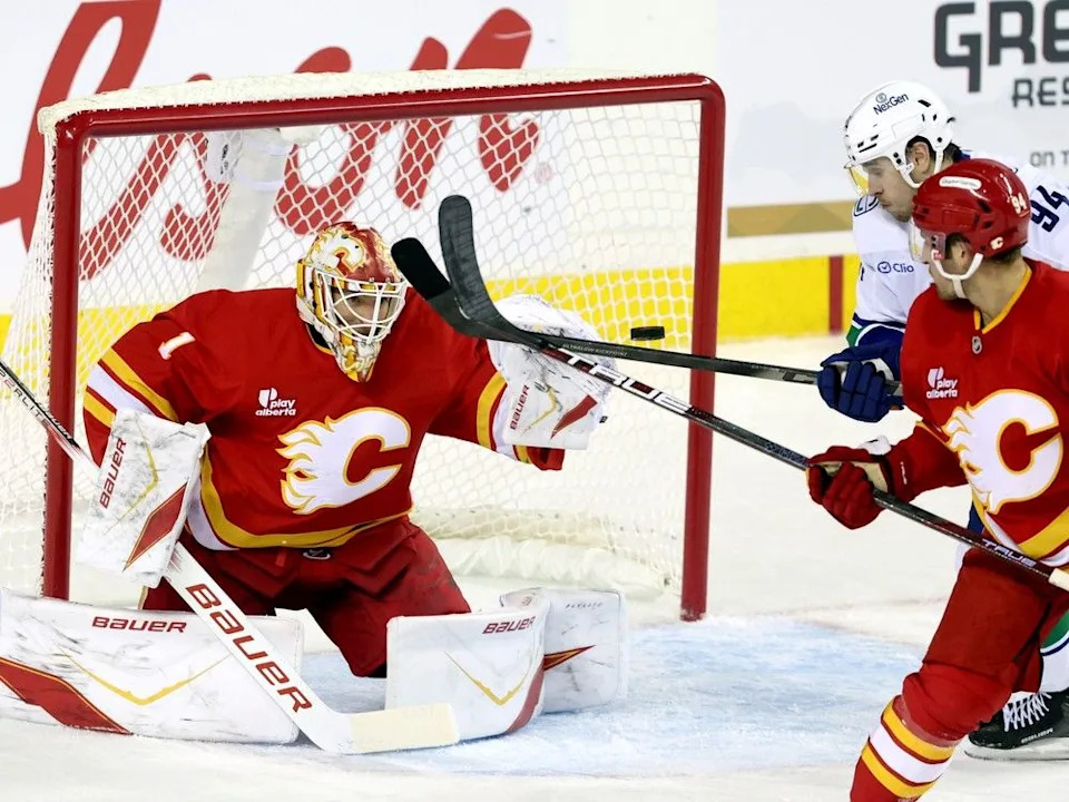  Flames goalie Devin Cooley stops Canucks forward Linus Karlsson on Wednesday.