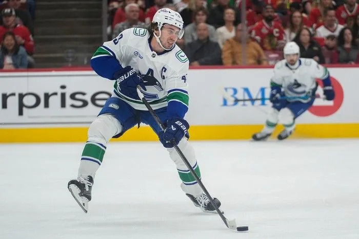  Vancouver Canucks defenceman Quinn Hughes handles the puck during the first period of an NHL hockey game against the Chicago Blackhawks, Friday.